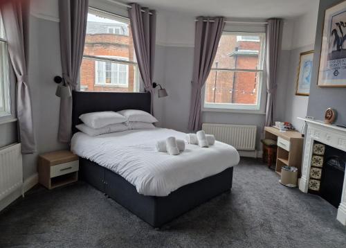 a bedroom with a bed with two teddy bears on it at Railway Hotel in Faversham