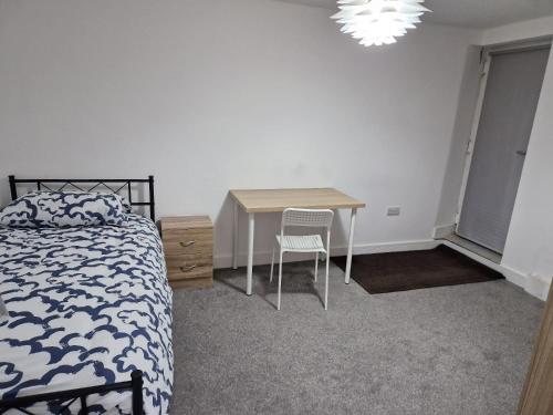 a bedroom with a bed and a desk and a table at Spacious single bedrooms in central location with parking in New Barnet