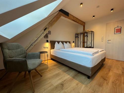 a bedroom with a bed and a chair in a attic at Gasthof - Auszeit im Bad Diezlings - Adults only in Hörbranz