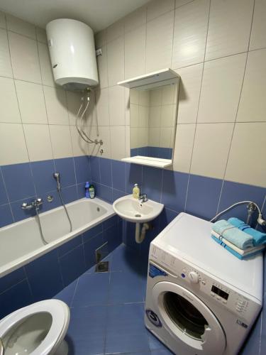 a bathroom with a washing machine and a sink at Apartman Atos stan na dan in Prijedor