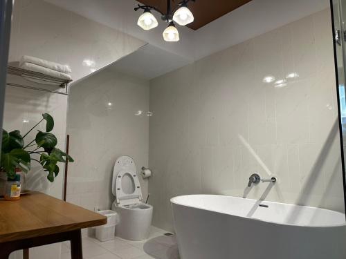 嘉義市的住宿－上水民宿，白色的浴室设有浴缸和卫生间。