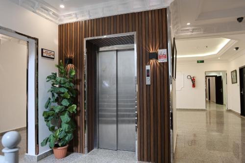 an elevator in a lobby with a plant at فندق الفالح للوحدات الفندقيه in Al Baha