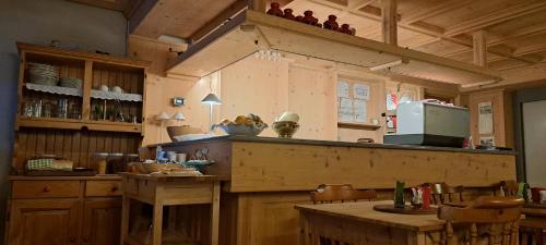 a kitchen with wooden cabinets and a counter with a table at Residence Weissthor in Macugnaga