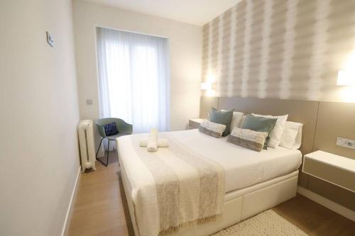 1 dormitorio con 1 cama blanca grande y ventana en Prime Location Modern Stay, en San Sebastián