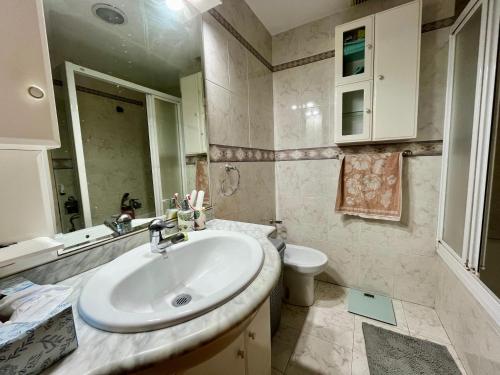 a bathroom with a sink and a toilet at Apartamento Compartido con Vista al Puerto Valencia in Valencia