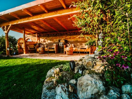 a wooden pergola with a table and chairs in a yard at Penzion U TŘÍ RŮŽÍ - Adults Only in Vrbice