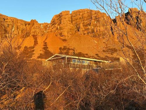 a house in front of a rocky mountain at Mulakot Cosy Cabins in Borgarnes