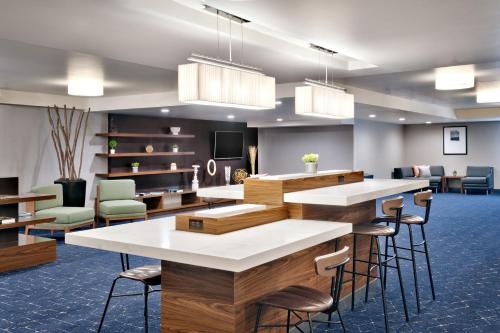 a lobby with tables and chairs in a room at Courtyard by Marriott Ogden in Ogden