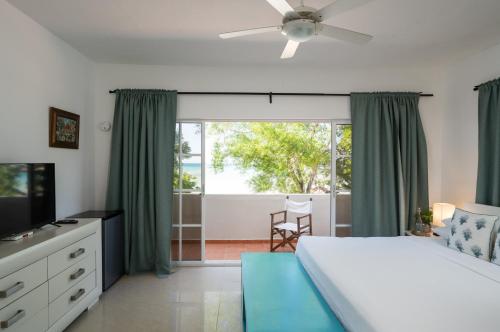 a bedroom with a bed and a large window at Blue Island Punta Rucia in Punta Rucia