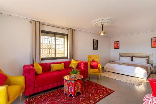 a living room with a red couch and a bed at leila farmhouse in Marrakech