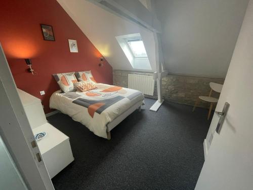 a bedroom with a bed with an orange wall at Maison Vue Panoramique in Saint-Pierre-Aigle