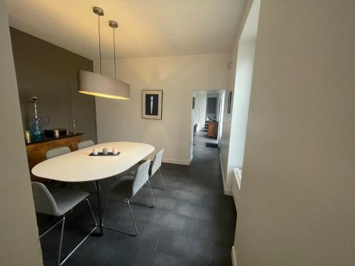 une salle à manger avec une table et des chaises blanches dans l'établissement Maison Vue Panoramique, à Saint-Pierre-Aigle