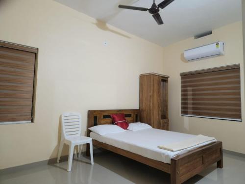 um quarto com uma cama e uma cadeira em Fathima Apartments em Iritti