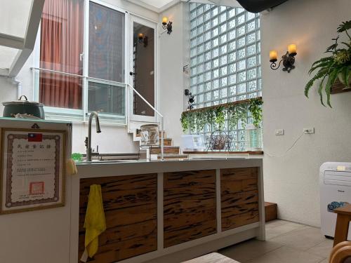eine Küche mit einem Waschbecken und zwei Fenstern in der Unterkunft 上水民宿 in Chiayi