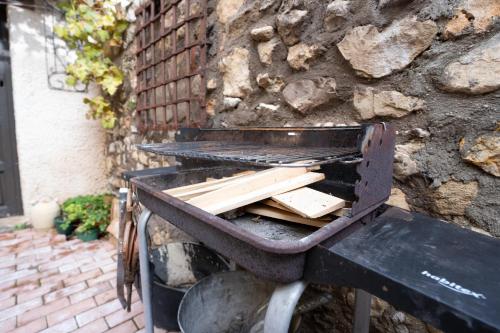 a grill with a pile of wood sitting on a bench at Casa Rural Los Arrieros in La Puerta