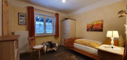 a bedroom with a bed and a desk and a chair at Pension Marianne - Chiemgau Karte in Inzell