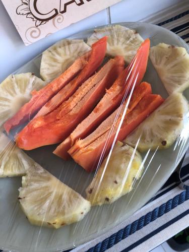 a plate of food with carrots and pineapple slices at Pousada Beira-mar I in Bertioga