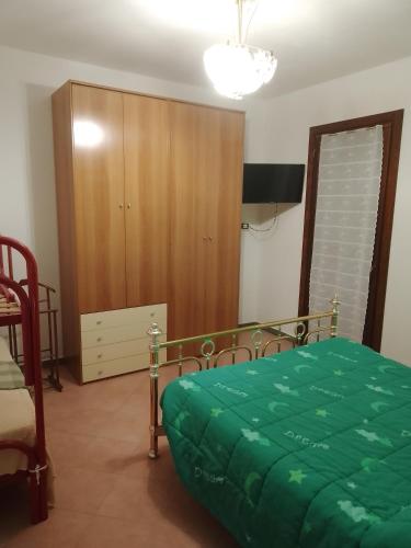 a bedroom with a bed and a wooden cabinet at Casa Artemis (Artemis House) in Cerreggio