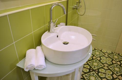 a white sink in a bathroom with towels on it at Hotel Ellique in Rhodes Town