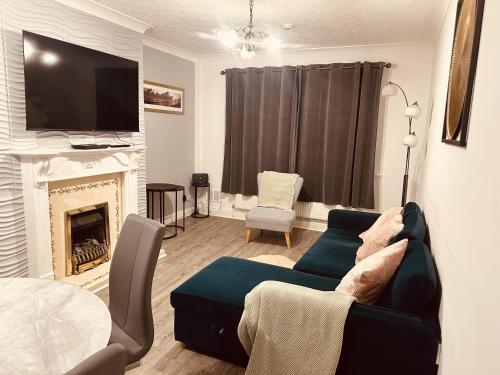 a living room with a couch and a fireplace at 3 Bed House - Sleeps 5 - Parking - Garden - Wifi in Blackburn