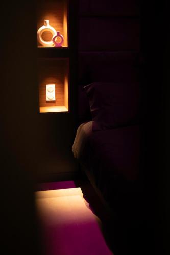 Cette chambre sombre comprend un lit et une fenêtre. dans l'établissement LV Suites Jaude, à Clermont-Ferrand