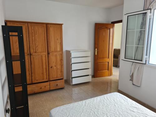 アレシーフェにあるGreat Room / Gran Habitacionのベッドルーム1室(木製キャビネット、ベッド1台、鏡付)