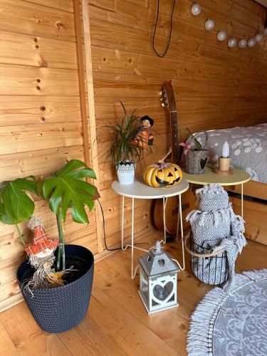a room with two tables and plants in a cabin at V dedine a predsa mimo nej v maringotke na samote in Dechtice