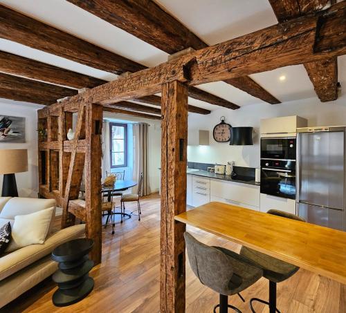 a kitchen and living room with wooden beams at Gîte Du XVe in Kaysersberg