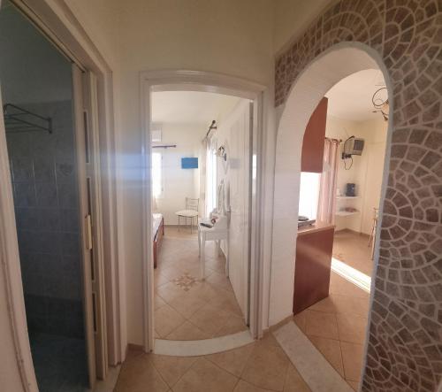 a hallway with an archway leading to a bathroom at Sophi's L Studios & Apartments in Agia Anna Naxos