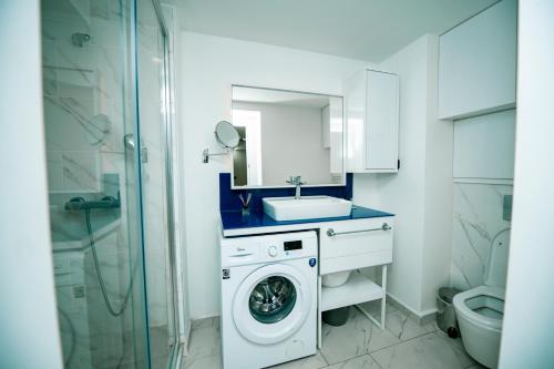 a bathroom with a washing machine and a sink at Orbi City Premium Apartments in Batumi