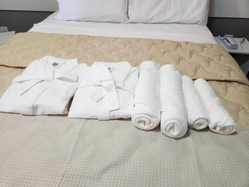 grupa białych ręczników na łóżku w obiekcie Vincenzo Hotel w mieście São Vicente de Minas