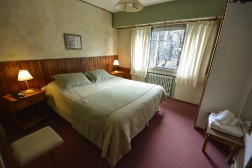 um quarto com uma cama grande e uma janela em Hostería Sur em San Carlos de Bariloche