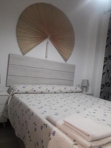 1 dormitorio con 1 cama con sombrilla encima en Apartamento Playa Blanca, en Melilla