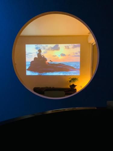 un miroir rond sur un mur avec une télévision dans l'établissement Chambre d’inspiration japonaise, à Pourrières