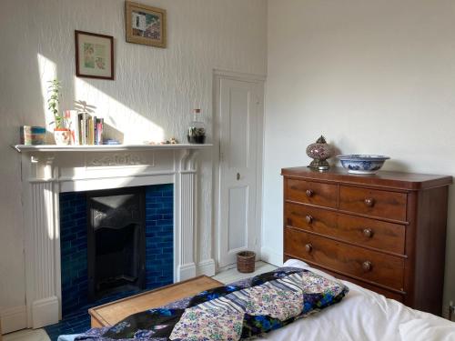 uma sala de estar com lareira e uma cómoda em Beautiful sunlit rooms, 2 mins from beach, private garden em Bridlington