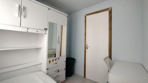 een witte slaapkamer met een bed en een spiegel bij Casa Mar azul in Torres