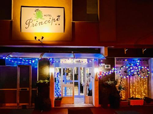 una tienda con luces de Navidad y una señal en Hotel Principe, en Pietra Ligure