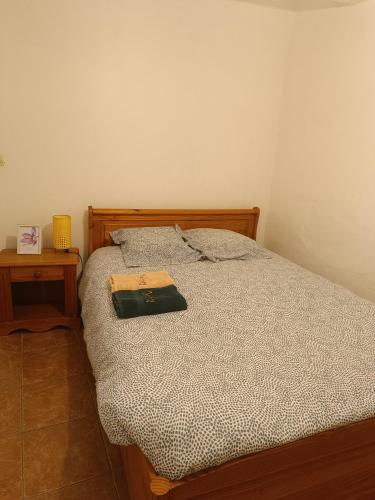 un lit avec un livre à côté d'une table dans l'établissement Chez Bichette Brignoles, à Brignoles