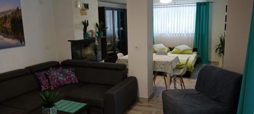 a living room with a couch and a dining room at Apartament in Maniowy