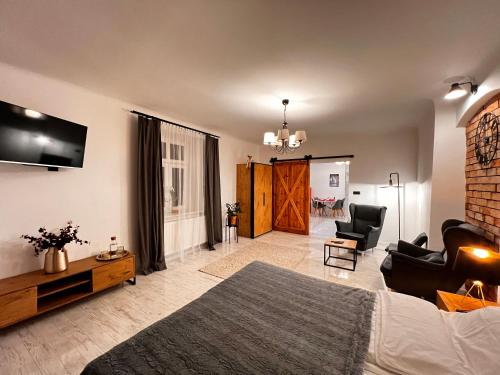 een woonkamer met een bed, een bank en een tv bij Apartament Grodzki in Przemyśl