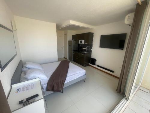 une chambre d'hôtel avec un lit et une télévision dans l'établissement Heliopolis E9, au Cap d'Agde