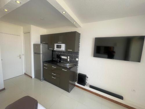 une cuisine avec un réfrigérateur en acier inoxydable et un micro-ondes dans l'établissement Heliopolis E9, au Cap d'Agde