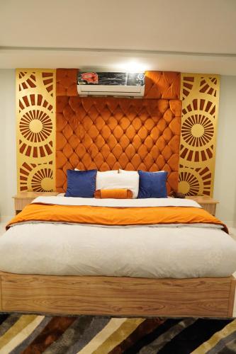 a bedroom with a large bed with blue pillows at NuvaHotel in Islamabad