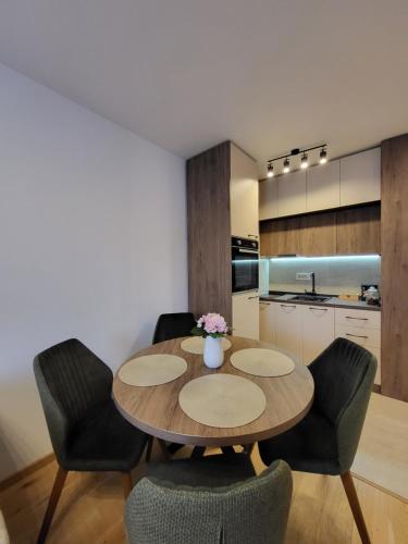 a kitchen and dining room with a wooden table and chairs at Apartman Restart Zlatibor in Zlatibor