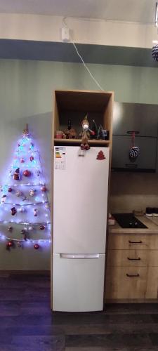 a kitchen with a christmas tree next to a refrigerator at Sunny apartment in Kechi House, Tsaghkadzor in Tsaghkadzor