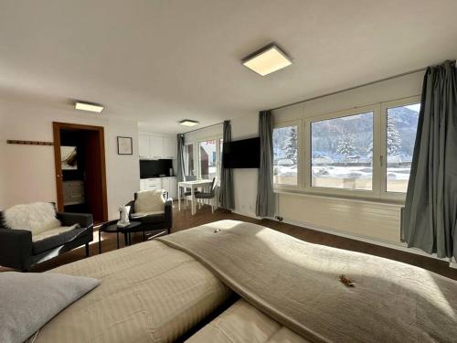 a bedroom with a large bed and a living room at Cozy loft for 2 near zermatt in Täsch