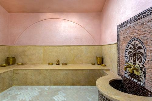 La salle de bains est pourvue d'une baignoire et d'un mur en briques. dans l'établissement leila farmhouse, à Marrakech