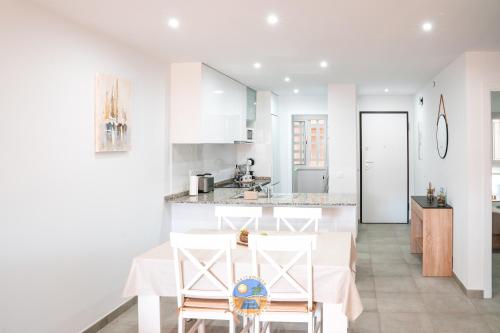 a white kitchen with a table and two chairs at Estrella Del Mar in San Juan de los Terreros