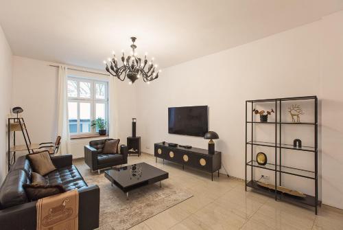 ein Wohnzimmer mit einem Sofa und einem TV in der Unterkunft Apartament Gryfita in Szczecinek