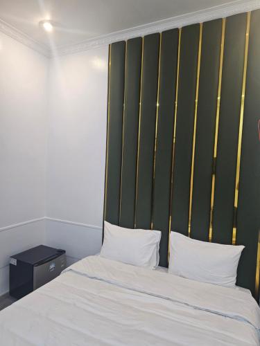 a bedroom with a bed with a green headboard at Milano Hotel in Hải Dương